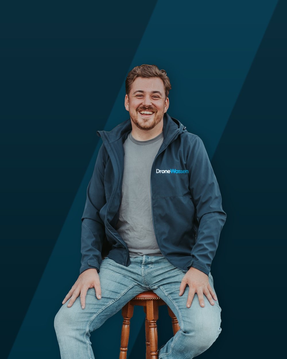 Davey Roeleven, eigenaar en dronepiloot van DroneWassen, in een jas met het DroneWassen-logo
